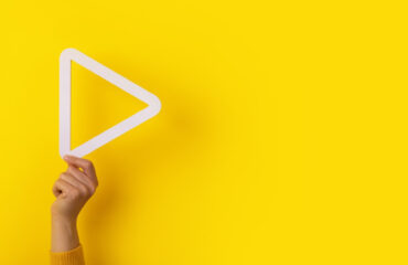 boton reproduccion multimedia 3d mano sobre fondo amarillo diseno panoramico